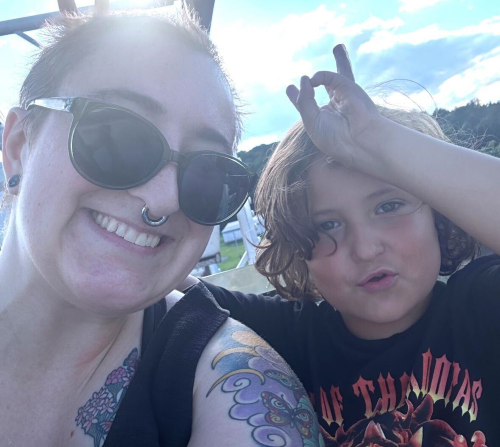 Kit, wearing sunglasses, next to Miles. They are on a Ferris Wheel